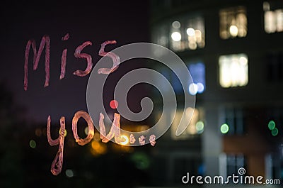 Miss you, inscription text by lipstick on the window glass in the night. Love concept. Stock Photo