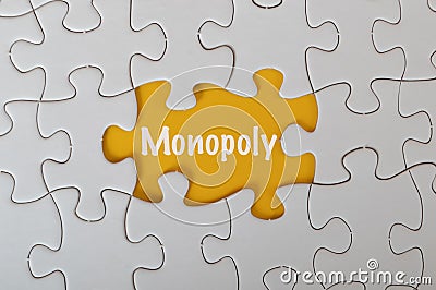 Missing jigsaw puzzle with text MONOPOLY isolated on a yellow background Stock Photo