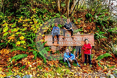 Cousins sitting on the sign at the entrance to Silverdale Creek Wetlands, a freshwater Marsh and Bog near Mission, BC, Canada Editorial Stock Photo