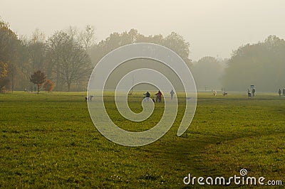 Misty autumn atmosphere in Niddapark Frankfurt. Many dog owners are out and about. Editorial Stock Photo