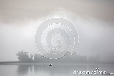 Misty autumn morning. Fishermen on the river in a boat Stock Photo