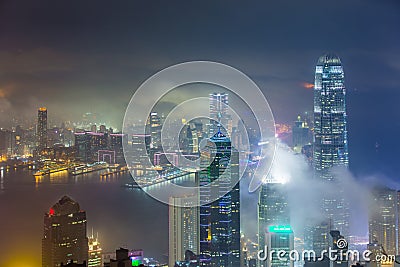 Misty city and Skyscraper in fog at night Stock Photo