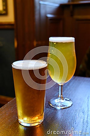 Misty glasses with two pints of cold Scotch ale, amber pale ale, lager draft beer in English pub Stock Photo