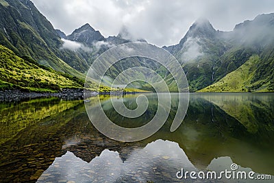 Misty mountain reflections in calm water, evoking a sense of mystery and introspection. Personal viewpoint Stock Photo