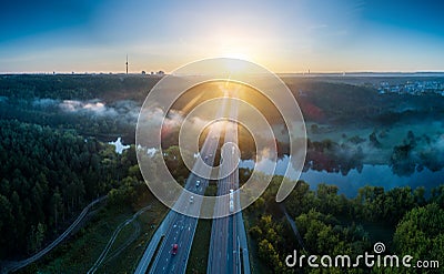 Misty sunrise landscape of road and river near town Stock Photo