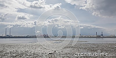 Misty view from across the water on Poolberg peninsula, with the chimneys of the power generation station , view from the beach Editorial Stock Photo