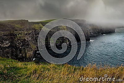 Misty view of of famous Cliffs of Moher and wild Atlantic Ocean, County Clare, Ireland Stock Photo