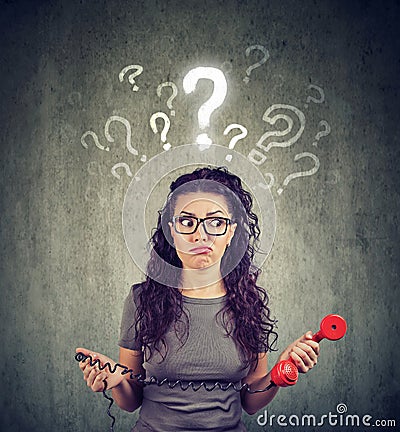 Upset worried confused woman with telephone has many questions Stock Photo