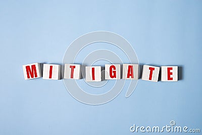 MITIGATE word made with building blocks on blue Stock Photo