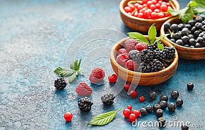 Mix of fresh berries with leaves on textured metal background Stock Photo