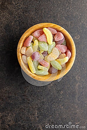 Mix of fruity jelly candy in wooden bowl. Top view Stock Photo