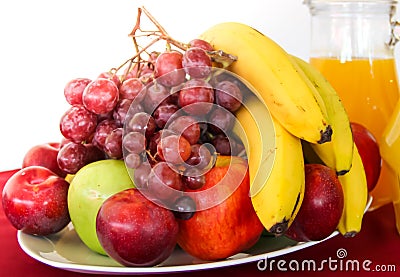 Mix of tropical organic fruits served on a plate and jugs of fresh juices Stock Photo