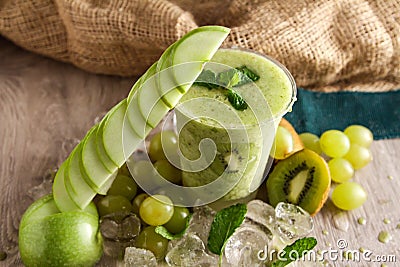 Mixed apple, kiwi and grapes smoothie served in disposable glass isolated on table side view of healthy drink Stock Photo