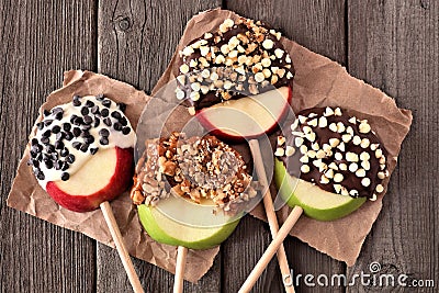 Chocolate and caramel dipped apple rounds, above on rustic wood Stock Photo