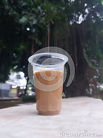 Mixed coffee drink in aqua glass. Looks beautiful taken on the edge of a ditch at Tanjung Duren Park, West Jakartaï¿¼ Stock Photo