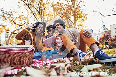 Family having fun while picnicking in the park make video call Stock Photo