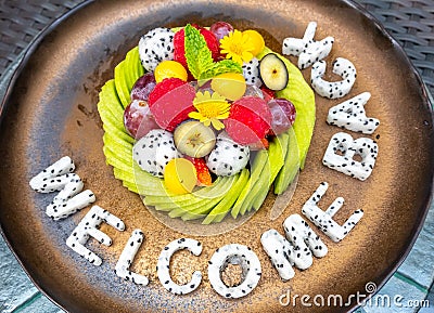 Mixed fruit, watermelon, melon, avocado, kiwi, strawberry, blueberry, dragon fruit, raspberry, decorated on dish with carving Stock Photo