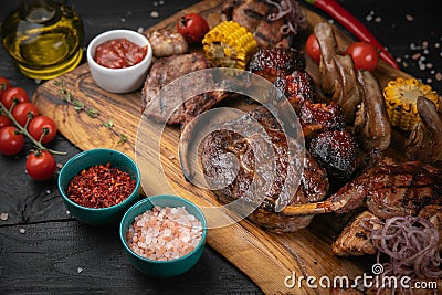 Mixed grilled meat platter on a black background Stock Photo