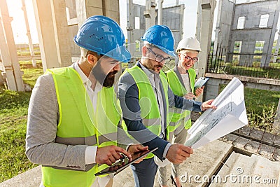 Mixed group of young architects and civil engineers or business partners meeting on a large construction site Stock Photo