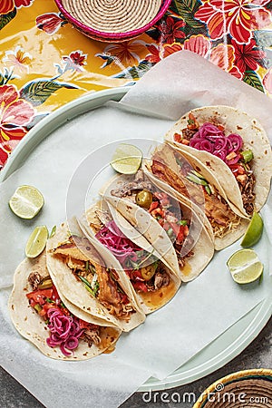 Mixed Mexican Tacos With Homemade Salsa, Limes And Parsley on bright traditional background. Stock Photo