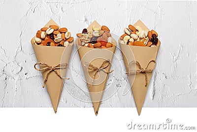 Mixed nuts and dried fruits in Retro Kraft Paper Cones on a light concrete background. Symbols of the Jewish holiday of Tu Bishvat Stock Photo