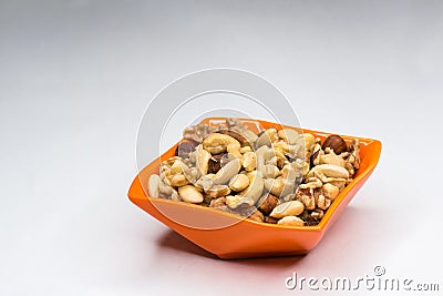 Mixed nuts in orange bowl isolated Stock Photo