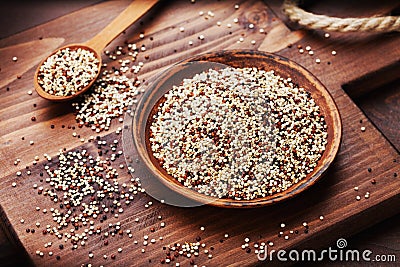 Mixed quinoa in bowl on wooden kitchen board. Stock Photo