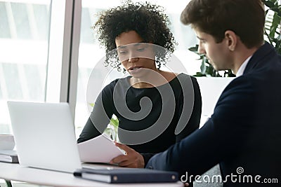 Multiracial colleagues analyzing financial report during meeting in office Stock Photo