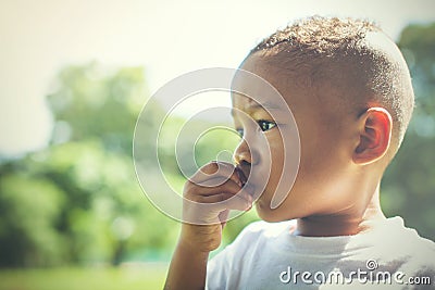Mixed race between Asian and African American kid thinking and being curious outdoor. Stock Photo