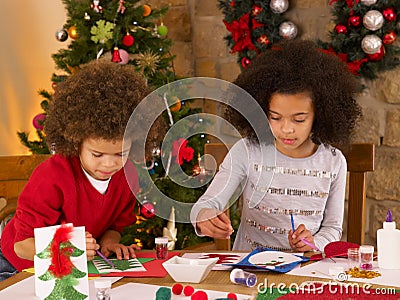 Mixed race children making Christmas cards Stock Photo