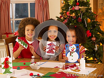 Mixed race children making Christmas cards Stock Photo