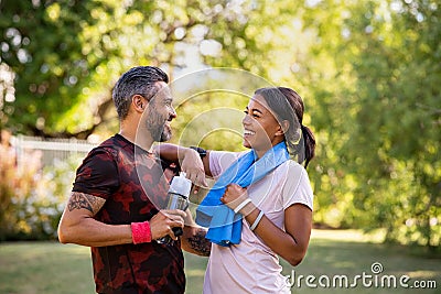 Mixed race couple taking a break after jog at park Stock Photo