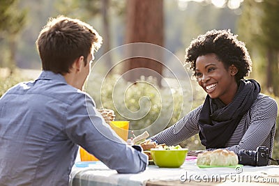 Mixed race couple talking at a picnic table, close up Stock Photo