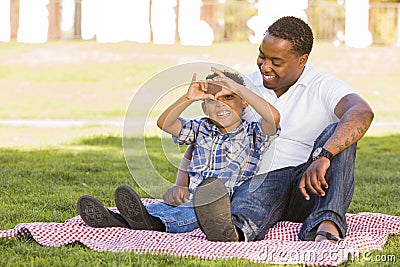 Mixed Race Father and Son Making Heart Hand Sign Stock Photo