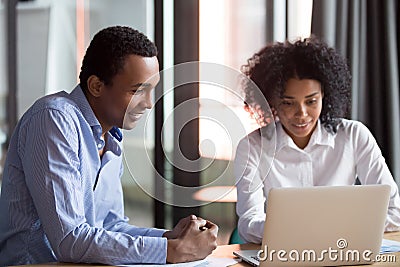 Mixed-race mentor manager consulting african client teaching employee with laptop Stock Photo