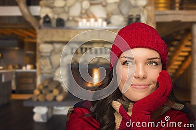 Mixed Race Girl Enjoying Warm Fireplace In Rustic Cabin Stock Photo