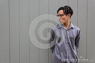 Mixed race millennial man, lips pursed in profile, hands behind back, open copy space Stock Photo