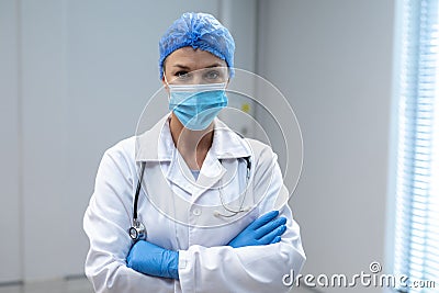 Mixed race mother and daughter hugging,daughter holding tedy bear with face mask Stock Photo