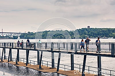 Mixed race people walking on the pedestrian footbridge over saint Lawrence river in Old Montreal Port Editorial Stock Photo