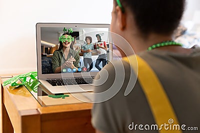 Mixed race woman making st patrick's day video call to smiling female friend on laptop at home Stock Photo