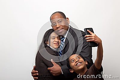 Mixed Raced Couple Posing for Photo and Son Taking Selfie with Smart Phone Stock Photo