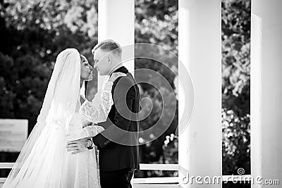 Mixed-racial newlyweds on a walk hugging and looking lovingly at each other, black and white photography Stock Photo