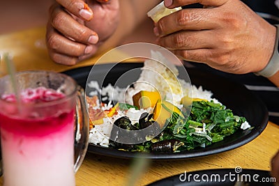 Mixed rice dish `Nasi Campur`, famous style of Malaysian food lunch served at a restaurant with drinks Stock Photo