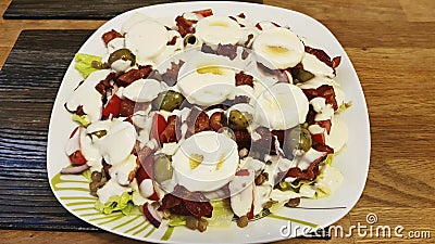 Mixed salad of eggs, olives, onion, dried tomatoes, cherry tomato and bacon. Stock Photo