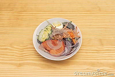 Mixed salad of oak lettuce, grated carrot, raw red onion, tomato slices, boiled Stock Photo