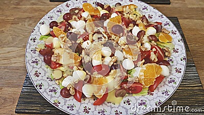 Mixed salad of tangerines, mozzarella, grapes and walnuts. Stock Photo