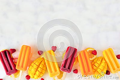 Mixed summer fruit popsicle bottom border on a white marble background Stock Photo