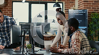 Mixed team of programmers brainstorming ideas for new cloud computing user interface looking at running code Stock Photo