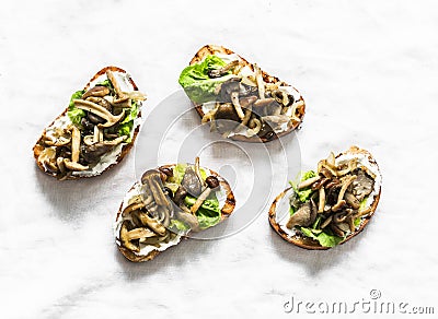 Mixed wild mushrooms cream cheese grilled bread sandwiches on a light background, top view Stock Photo