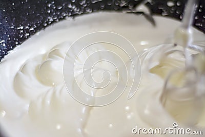 The mixer mixes thick, white cream Stock Photo